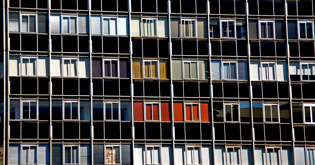 A vibrant facade of a modern apartment building with varied window colors and patterns.
