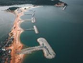 Aerial view of small settlement located on sandy shore near calm sea water