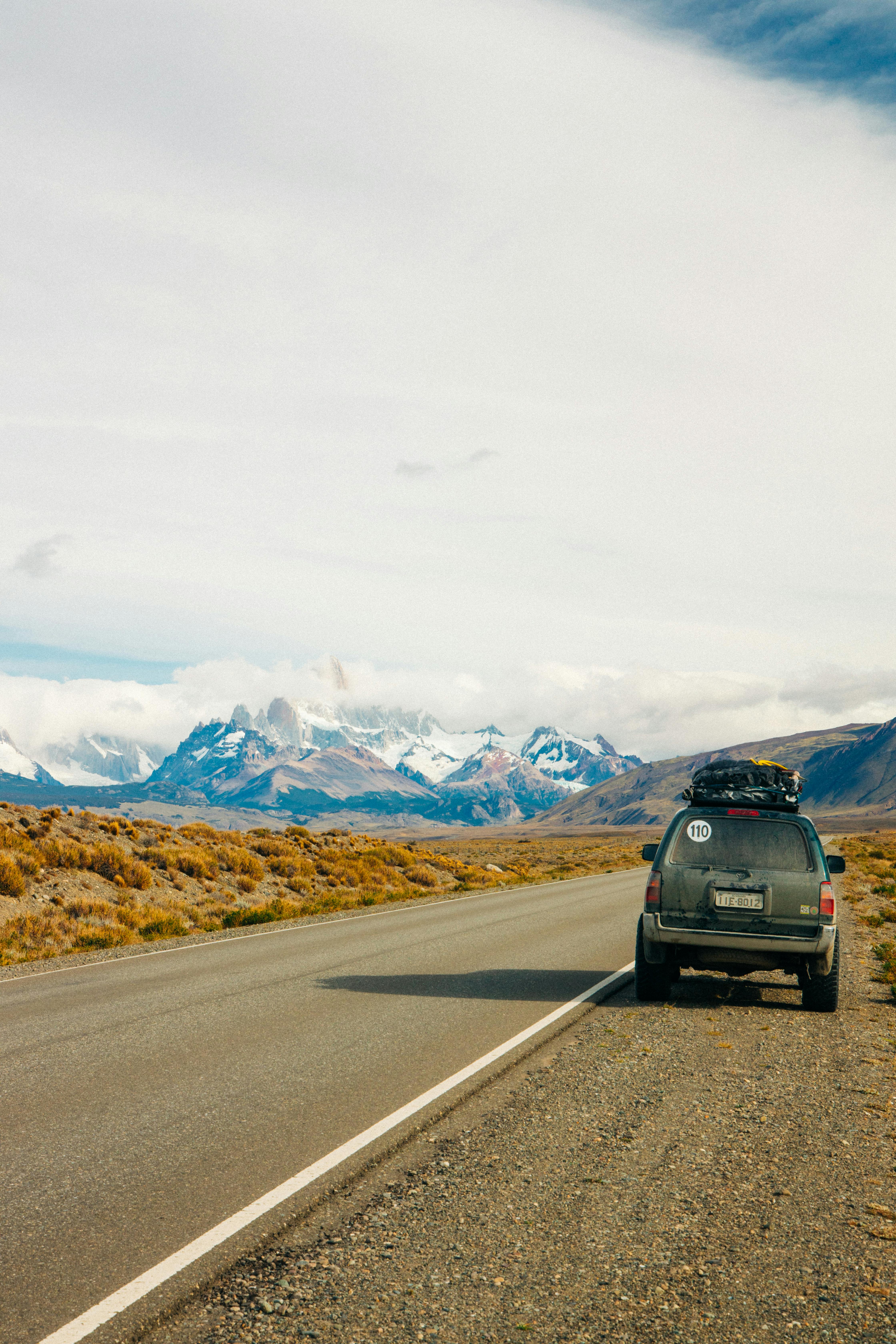 在阿根廷埃尔查尔滕，一辆汽车停在道路上，背景是令人惊叹的山景