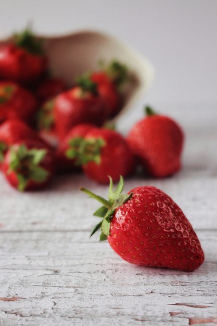 Vibrant close-up of fresh strawberries on a rustic wooden surface. Perfect for food and healthy living themes.