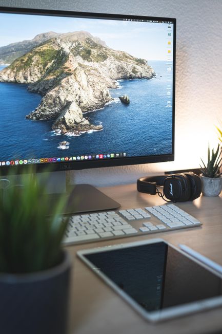 Fotomural Una configuración de escritorio elegante y organizada con un monitor de ordenador, teclado, tableta y auriculares.