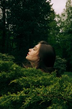 森林中，一名闭着眼睛的女子侧影被郁郁葱葱的绿叶环绕