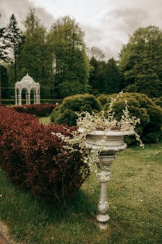 White Concrete Fountain Surrounded by Green Grass and Trees with the Quote "People ask me what I do in winter when there's no baseball. I'll tell you what I do. I stare out the window and wait for spring." written on it and have average color value #5B5B41