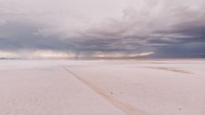 Snow Covered Field Under Cloudy Sky