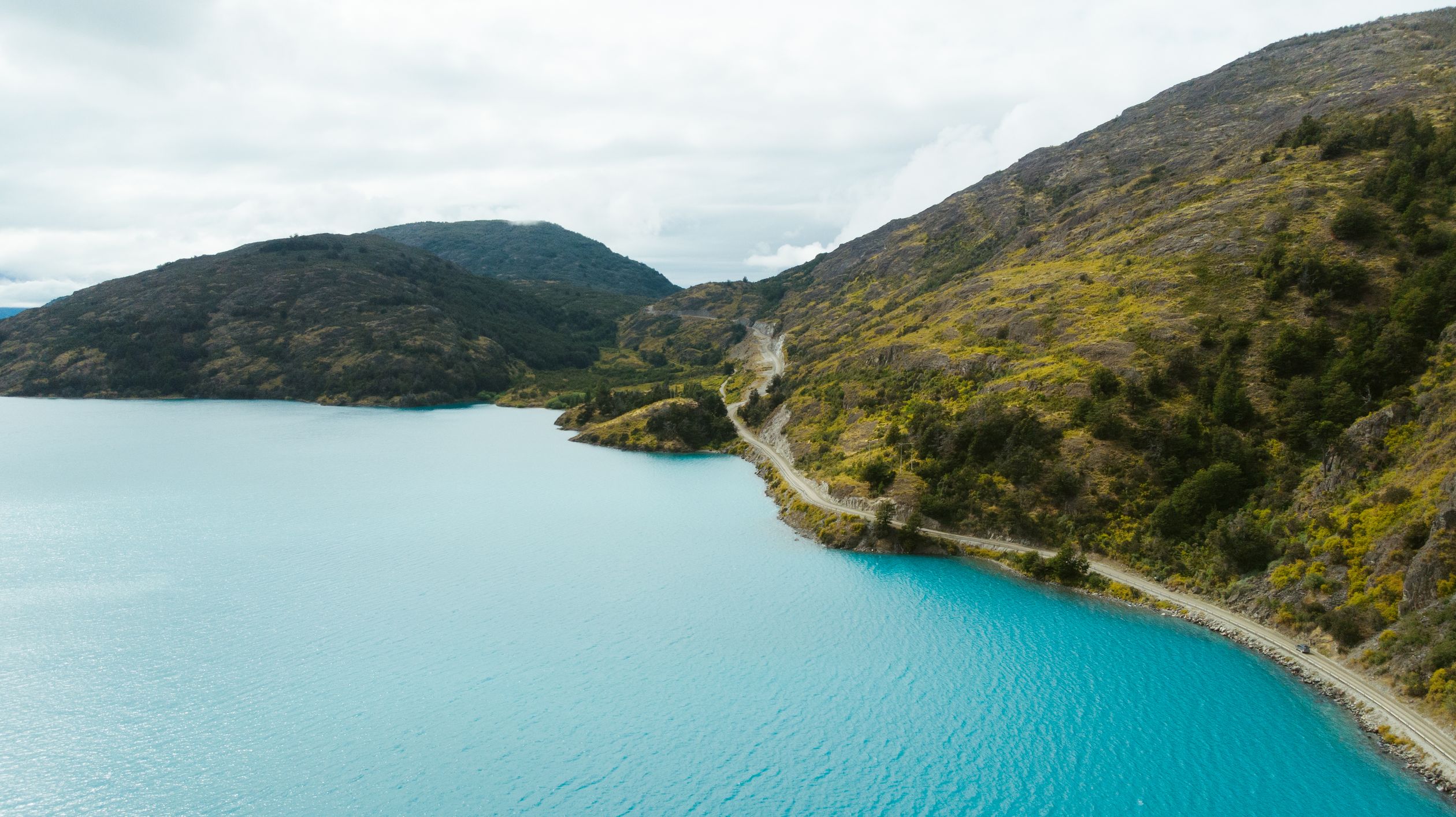 Breathtaking aerial view of a serene lake and winding road in Puerto Montt, Chile.