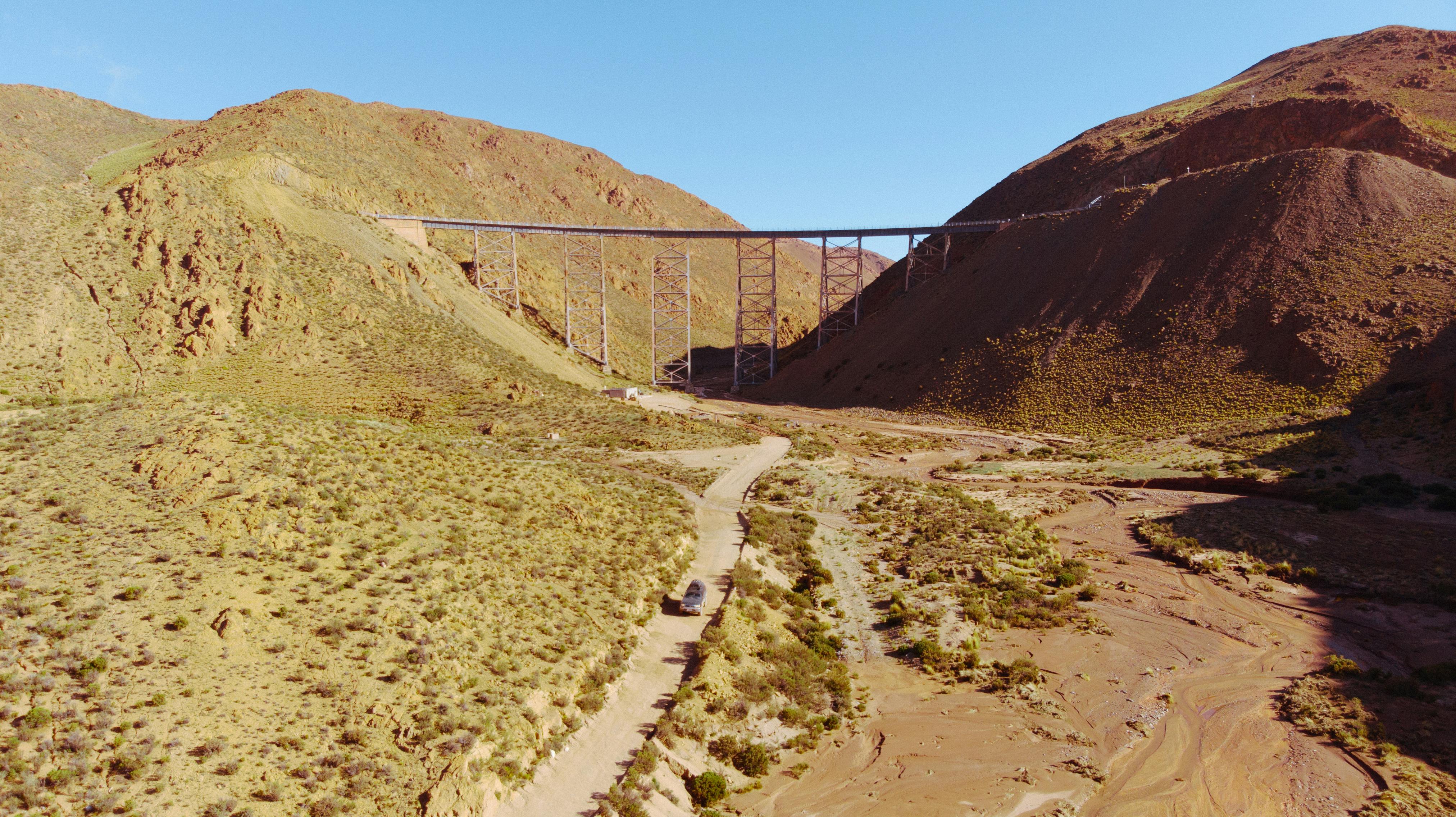 在晴朗的天空下，空中拍摄了阿根廷干旱地区一座横跨干燥山谷的桥梁