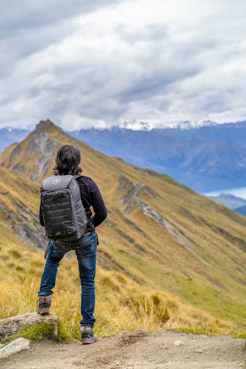 Unrecognizable hiker looking at mountain ridge