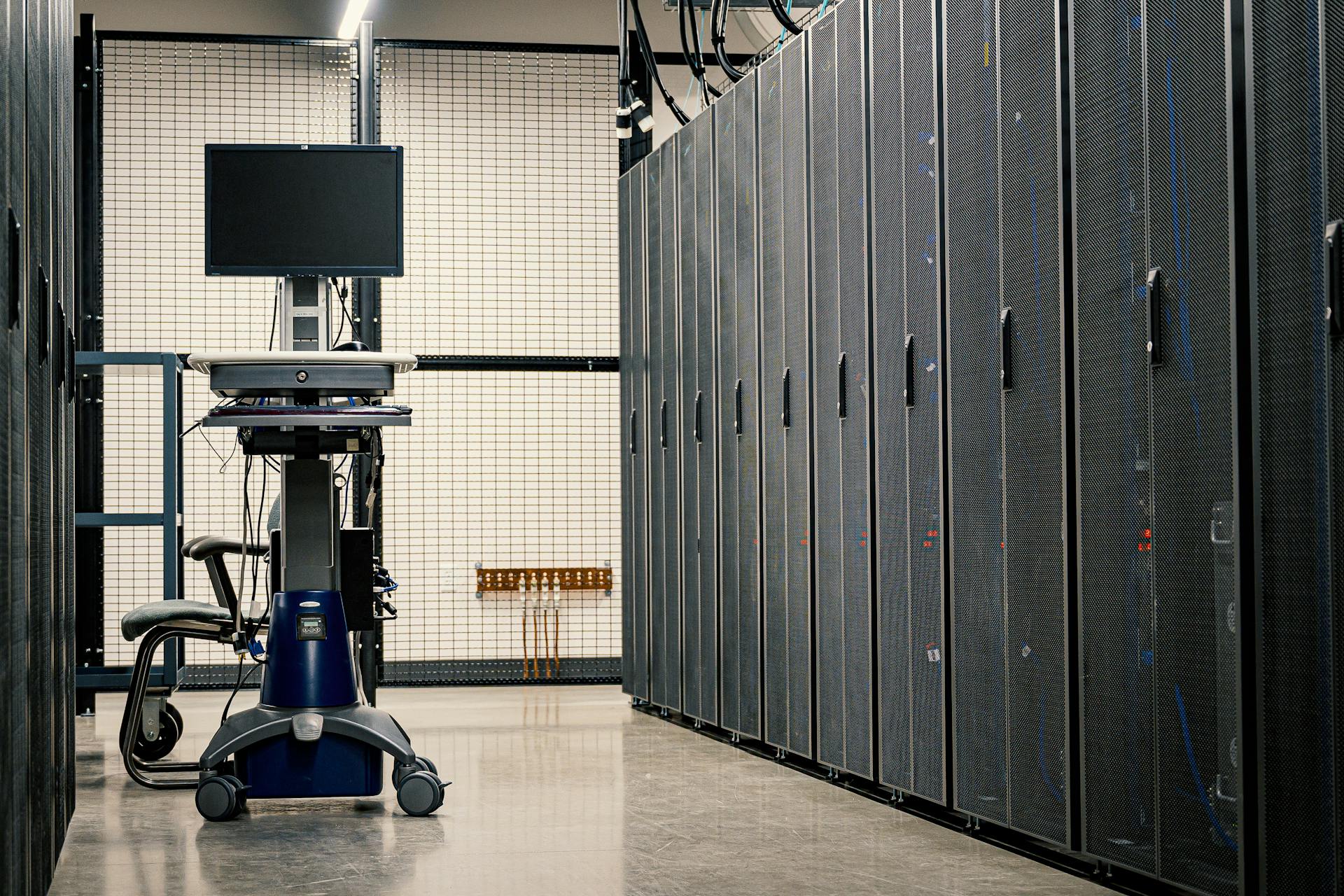 Contemporary computer on support between telecommunication racks and cabinets in modern data center