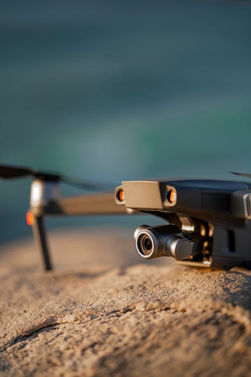 Contemporary UAV with propeller recording video on bristly mount on blurred background in daylight