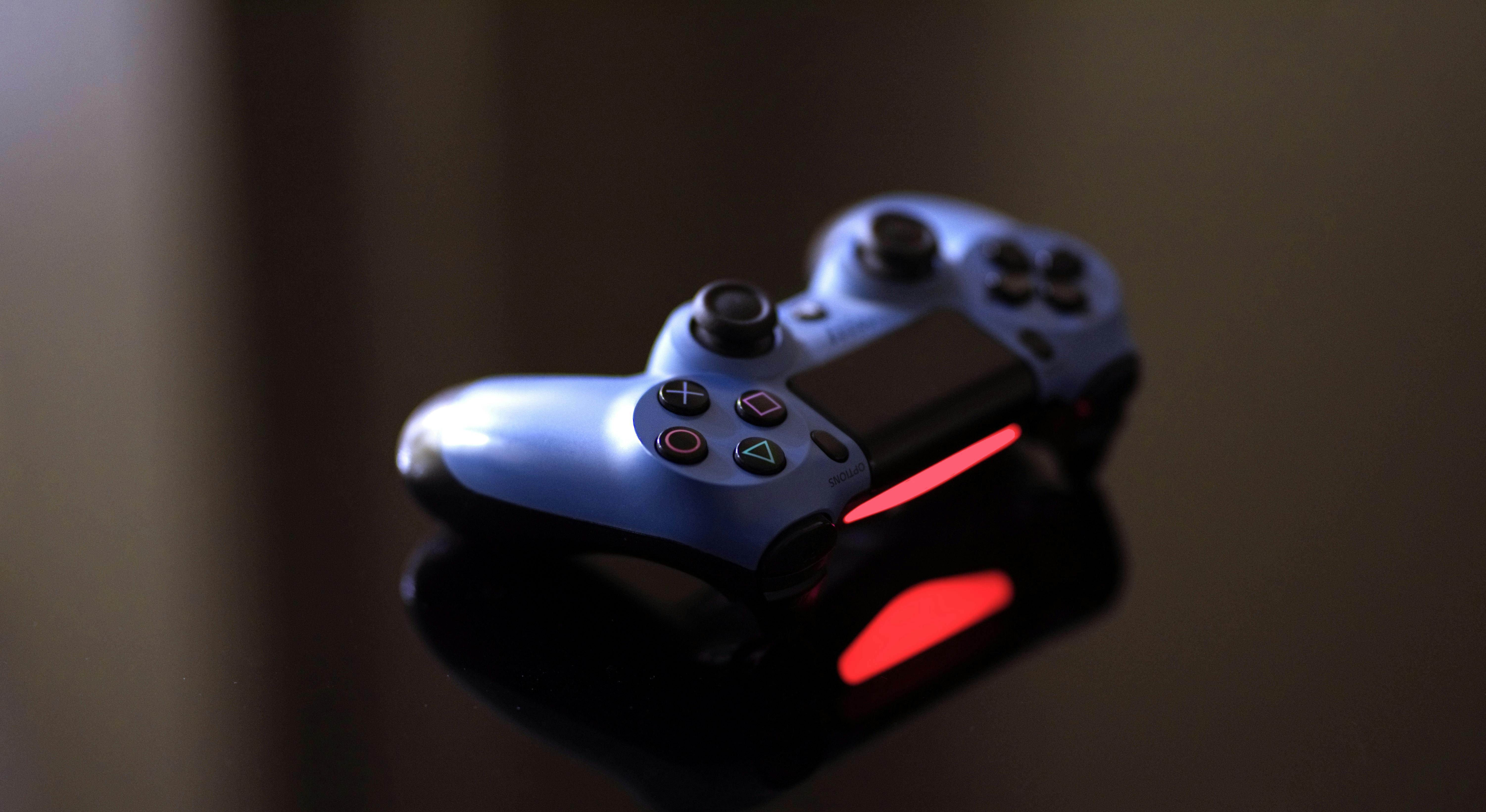 Black Wireless Game Controller on Black Leather · Free Stock Photo