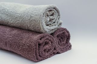 Rolled household towels in neutral tones — photo by Dom J on Pexels