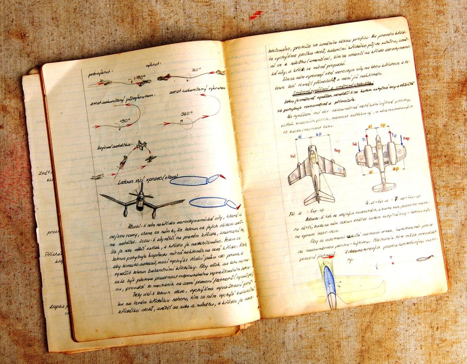 Free Open vintage notebook showing airplane diagrams and handwritten notes on aged paper. Stock Photo