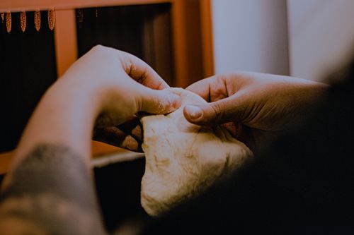 Free Hands kneading dough with focus on texture and technique in a warm kitchen setting. Stock Photo