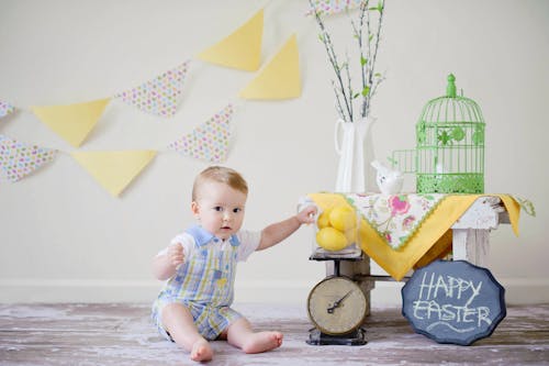 Free Baby Sitting on Floor Surface Near Table and White Wall Stock Photo