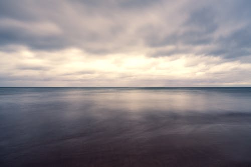 Tranquil blue sea under cloudy overcast sky