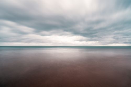Free Long exposure scenery of dramatic cloudy sky over tranquil blue sea on overcast weather Stock Photo