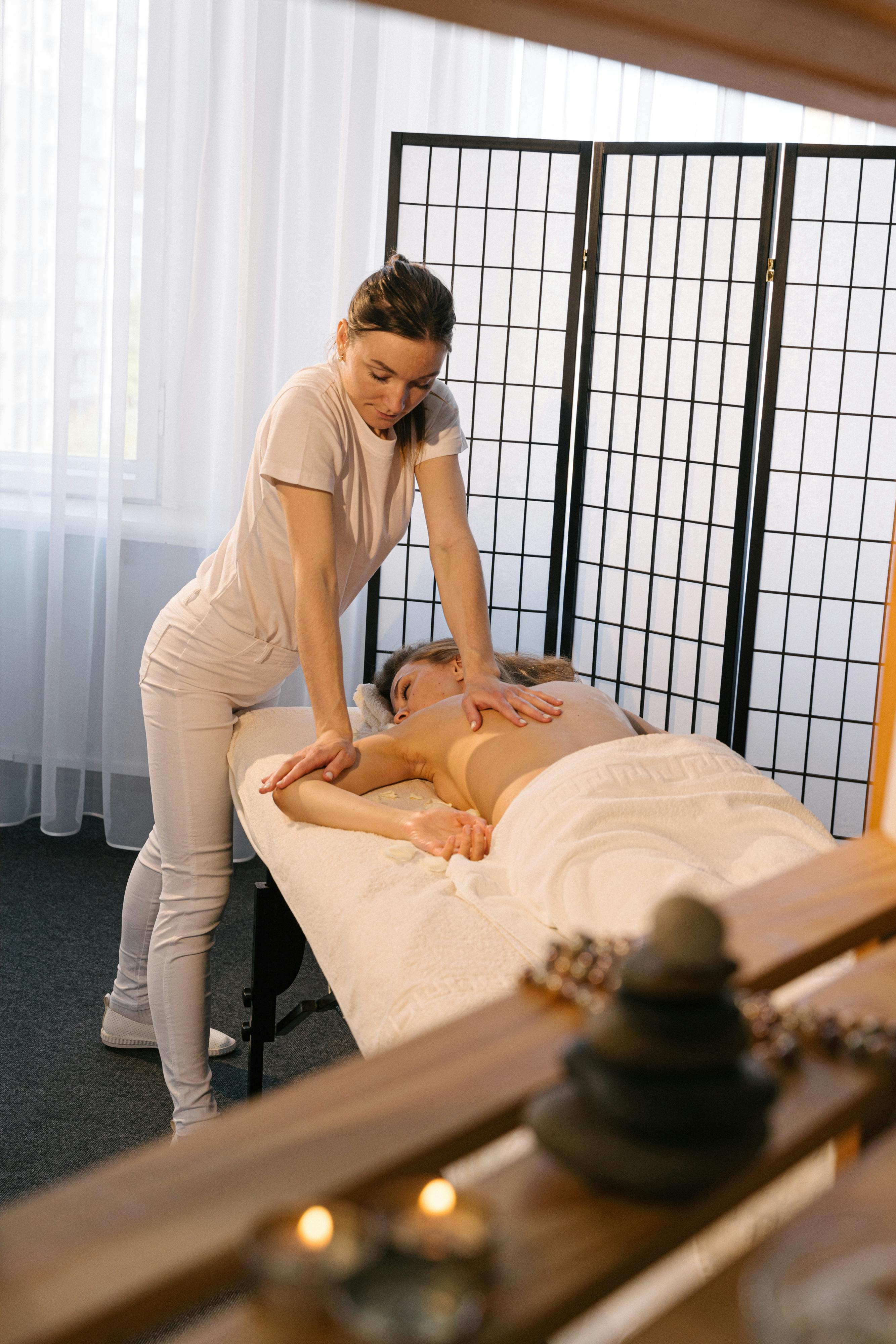 a massage therapist massaging a woman s arm