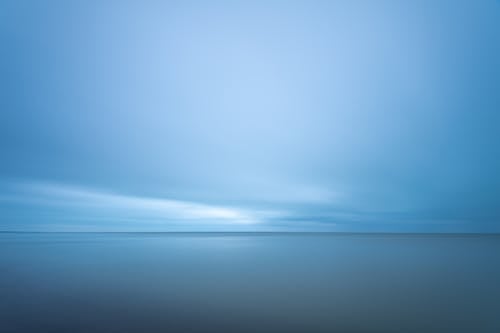 Blue seascape under cloudy evening sky