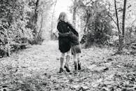 Woman Walking on Pathway Between Green Trees