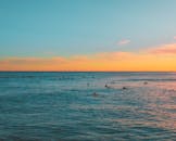 冲浪者沐浴在美丽的夏威夷日落的金色光芒中