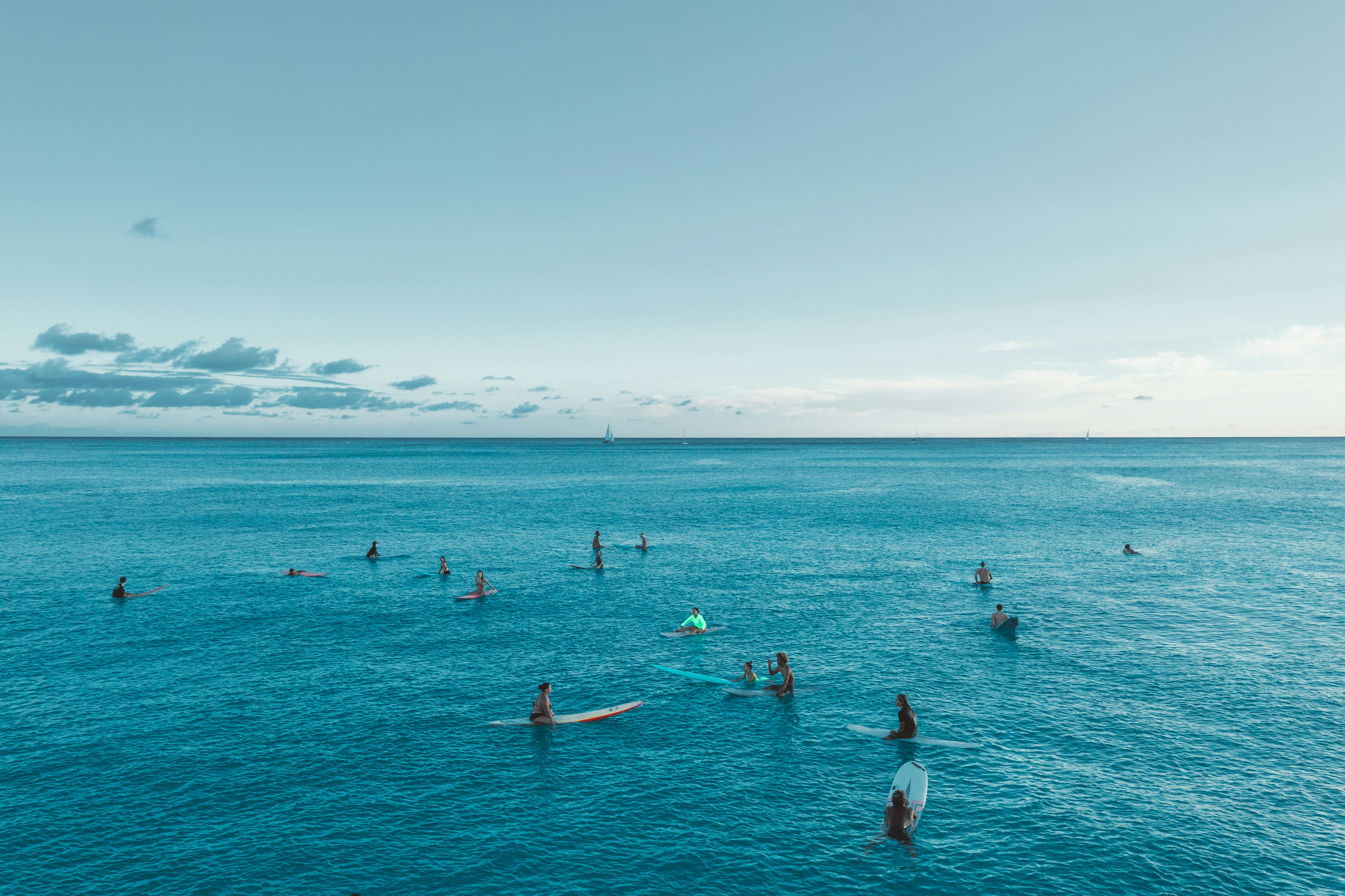 从高空俯瞰，夏威夷蔚蓝海洋中的冲浪者，捕捉了岛屿生活与冒险的精髓