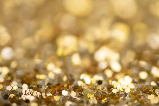 Vibrant and shimmering golden glitter with a soft bokeh effect, perfect for festive and artistic themes.