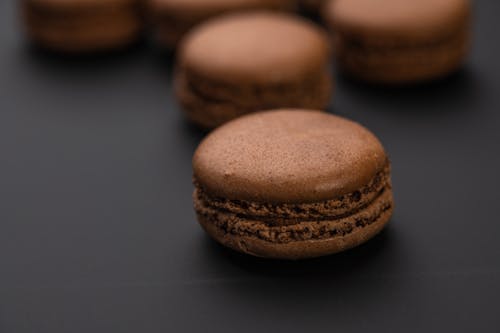 Chocolate sweet tasty macaroons on black background