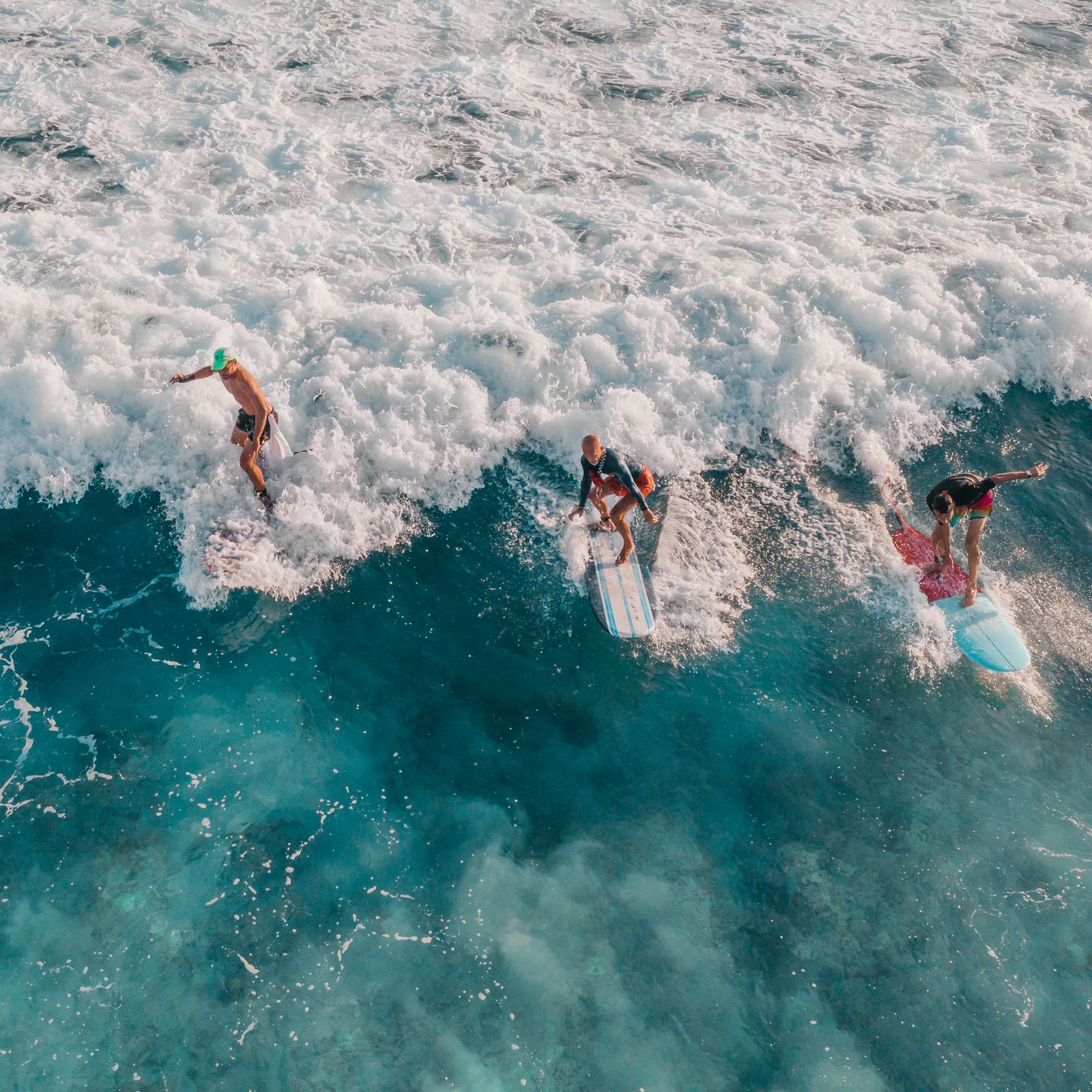 Aerial view of surfers paddling out to catch ocean waves