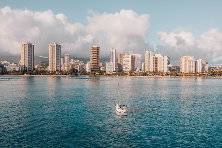 Stunning Exceptional Maui Whale Watch Review: A Luxury Encounter with Hawaii's Giants Review 2026 - A serene aerial shot of Waikiki's skyline and a sailboat in Honolulu, Hawaii.