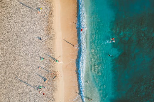 Breathtaking aerial view of a Hawaiian beach with beachgoers and turquoise waters.