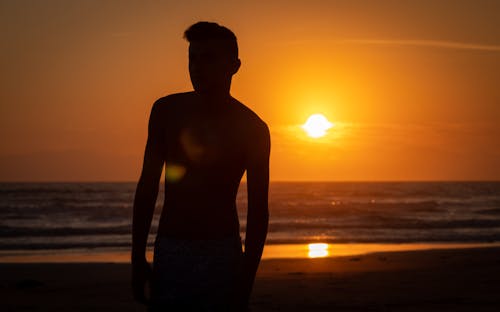 Silhouette of a Man Standing on the Beach