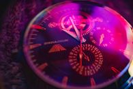 Stylish close-up of a luxury analog wristwatch with vibrant lighting.