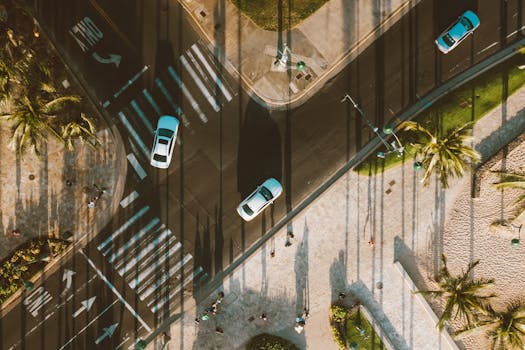 Aerial view of street intersection in Honolulu, Hawaii with cars and pedestrian lanes.