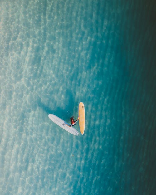 Aerial View of Person Riding on White Boat on Blue Sea