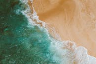 航拍照片捕捉宁静的绿松石波浪在夏威夷的沙滩上相遇