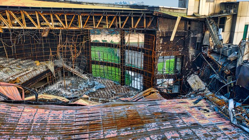 Drone shot of a fire-damaged building in Banten, Indonesia showing twisted metal and rubble.