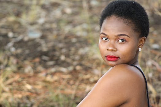 Portrait of a woman with short hair and red lips in an outdoor setting.