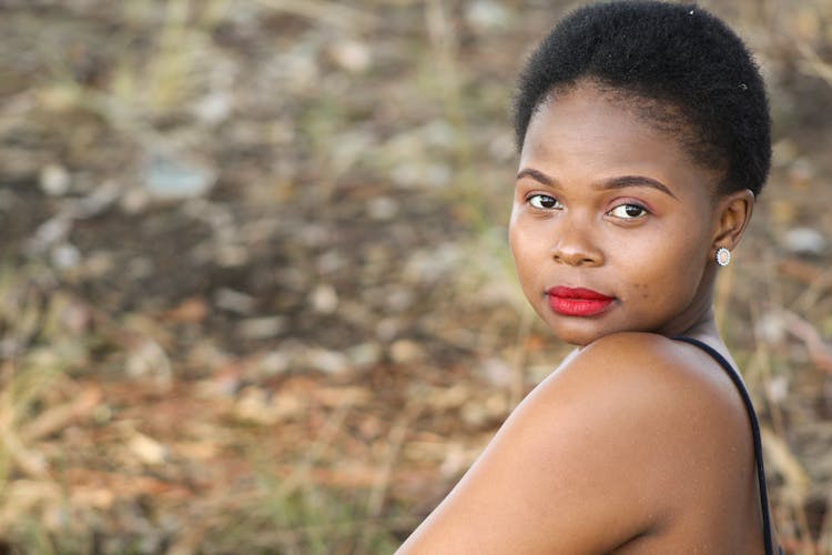 Pleased Black Woman Sitting On Grass