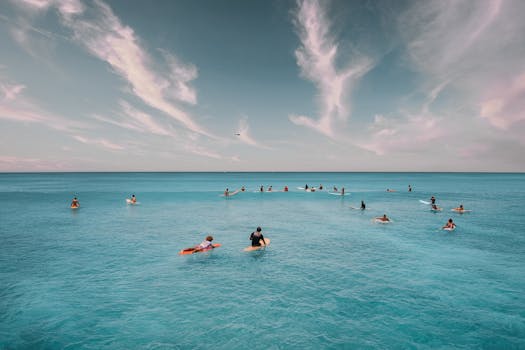 Aerial shot of surfers waiting for waves on the clear blue ocean near Hawaii.