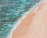 这张航拍照片展现了夏威夷普普基亚海滩沙质海岸与碧绿海水交织的美丽海岸线