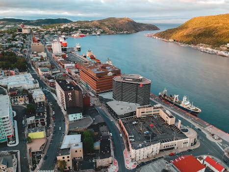 Aerial shot of St. John's harbor with vibrant cityscape and ships by the water.