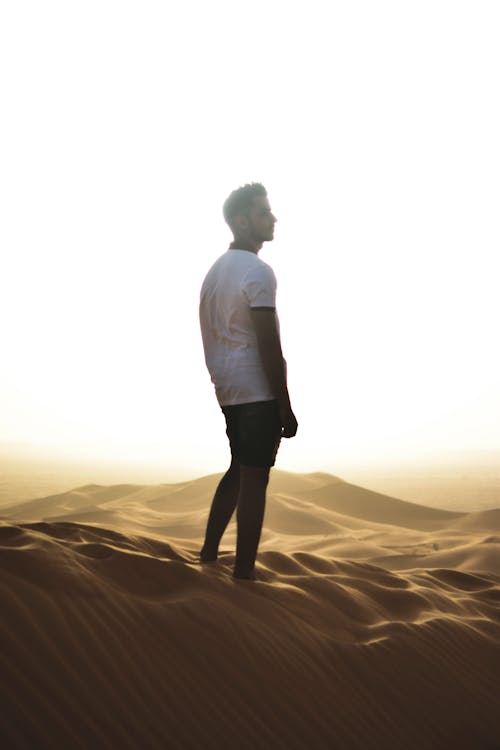 A Man in White T-Shirt Standing on the Sand
