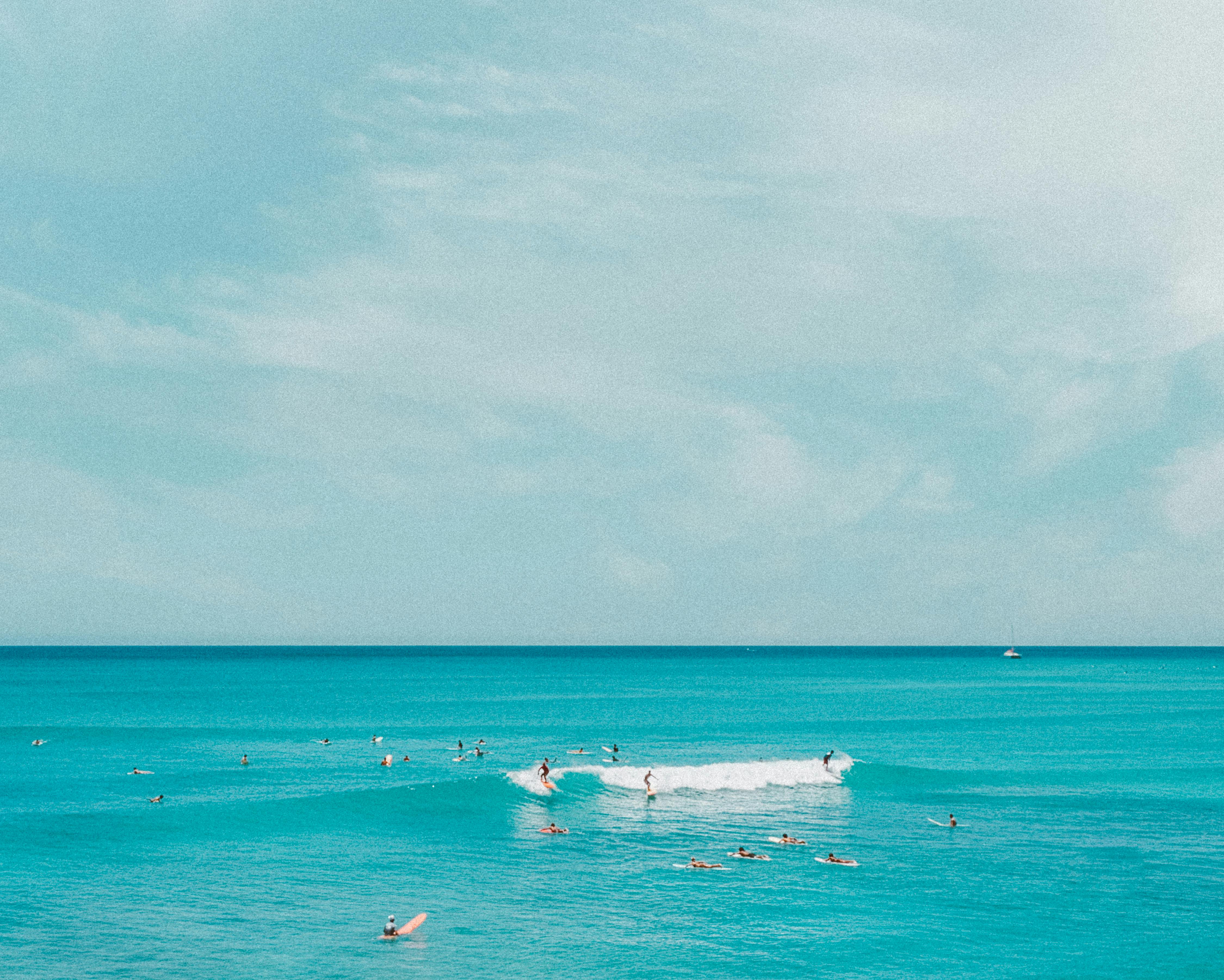 冲浪者在夏威夷碧绿的海洋中捕捉海浪，从上面看