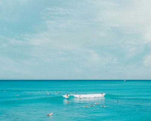 Free People Surfing on Sea Stock Photo
