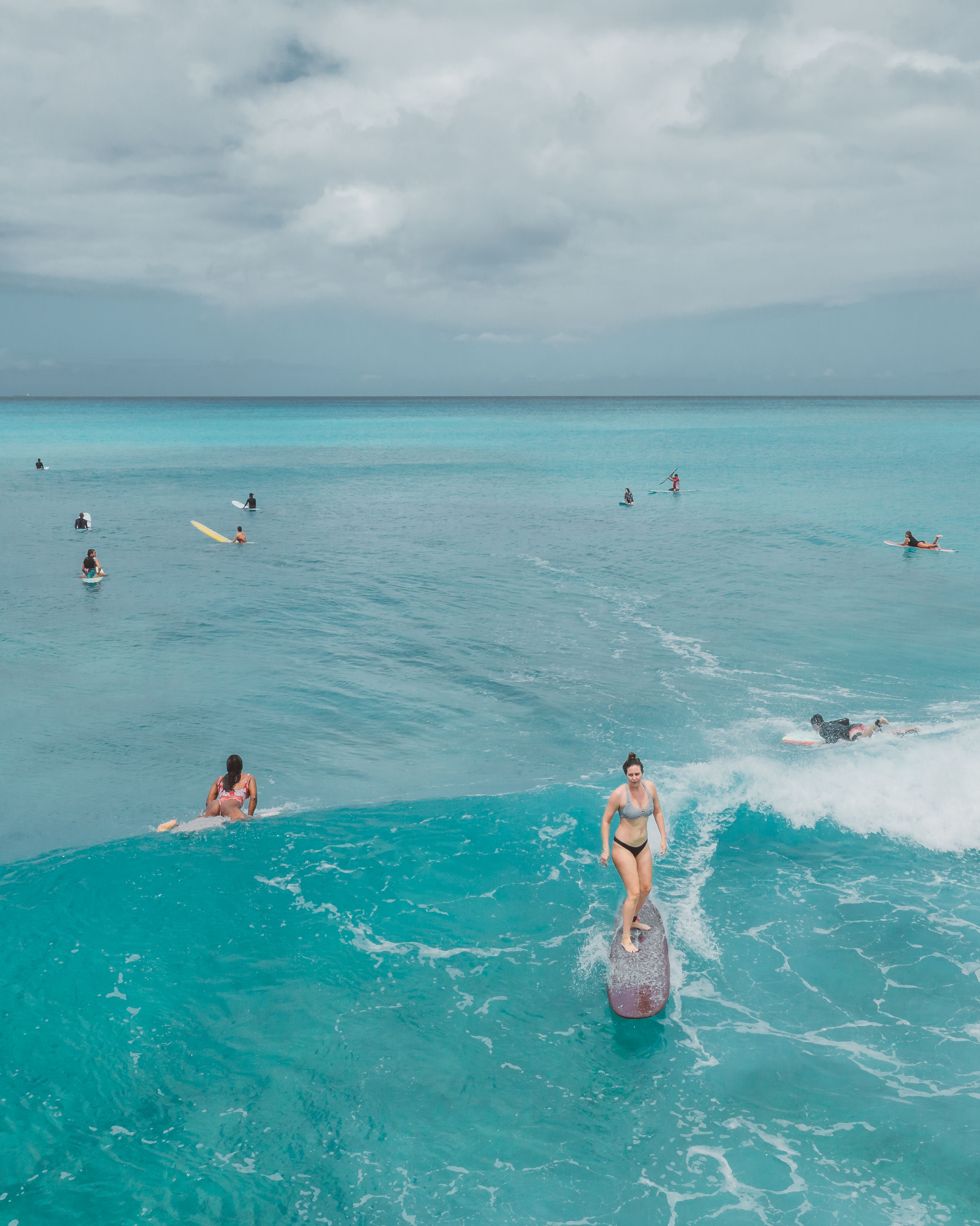 Surfers and the ocean along a tropical beach coast