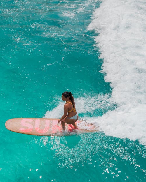 Woman in Pink Bikini Surfing on Sea Waves