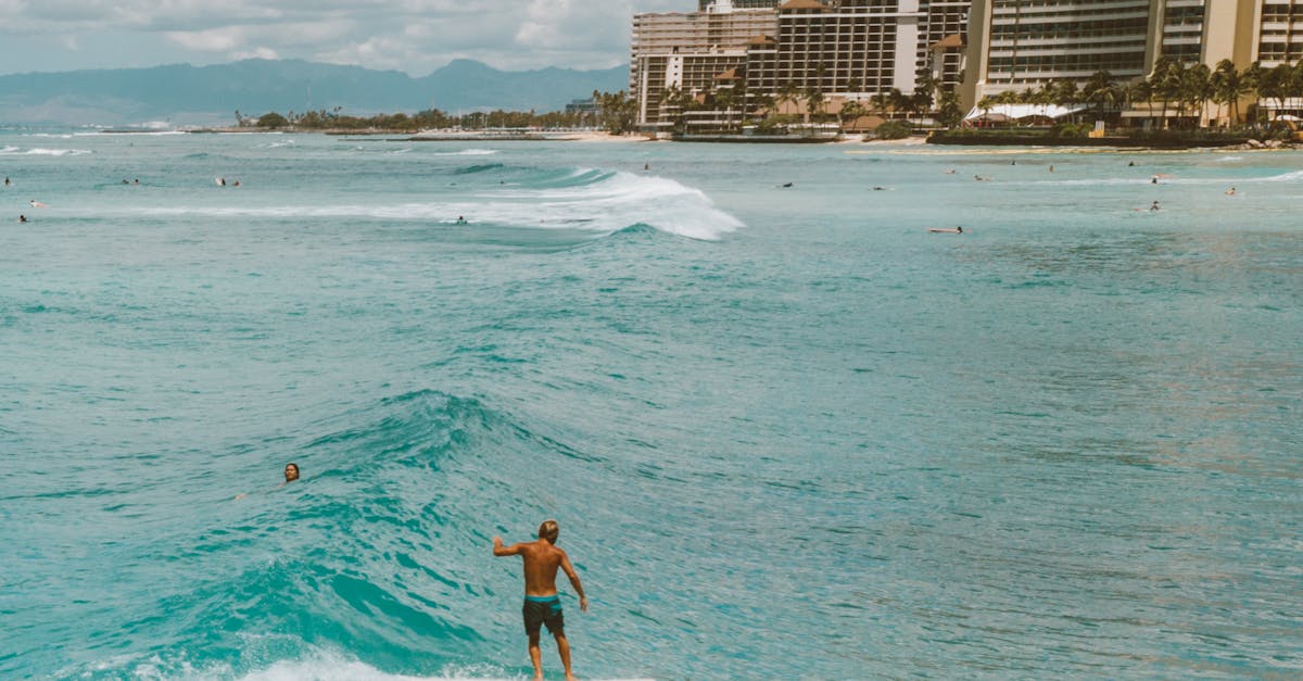 Photo by Jess Loiterton Exciting surf scene with a surfer skillfully riding waves at Waikiki Beach, Hawaii.