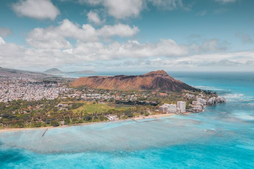 Stunning aerial view of Diamond Head with turquoise ocean and vibrant Honolulu cityscape.