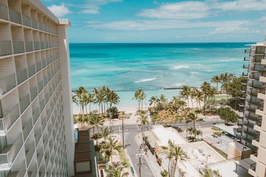 Breathtaking view of Waikiki Beach and palm trees from a hotel balcony in Honolulu, Hawaii.