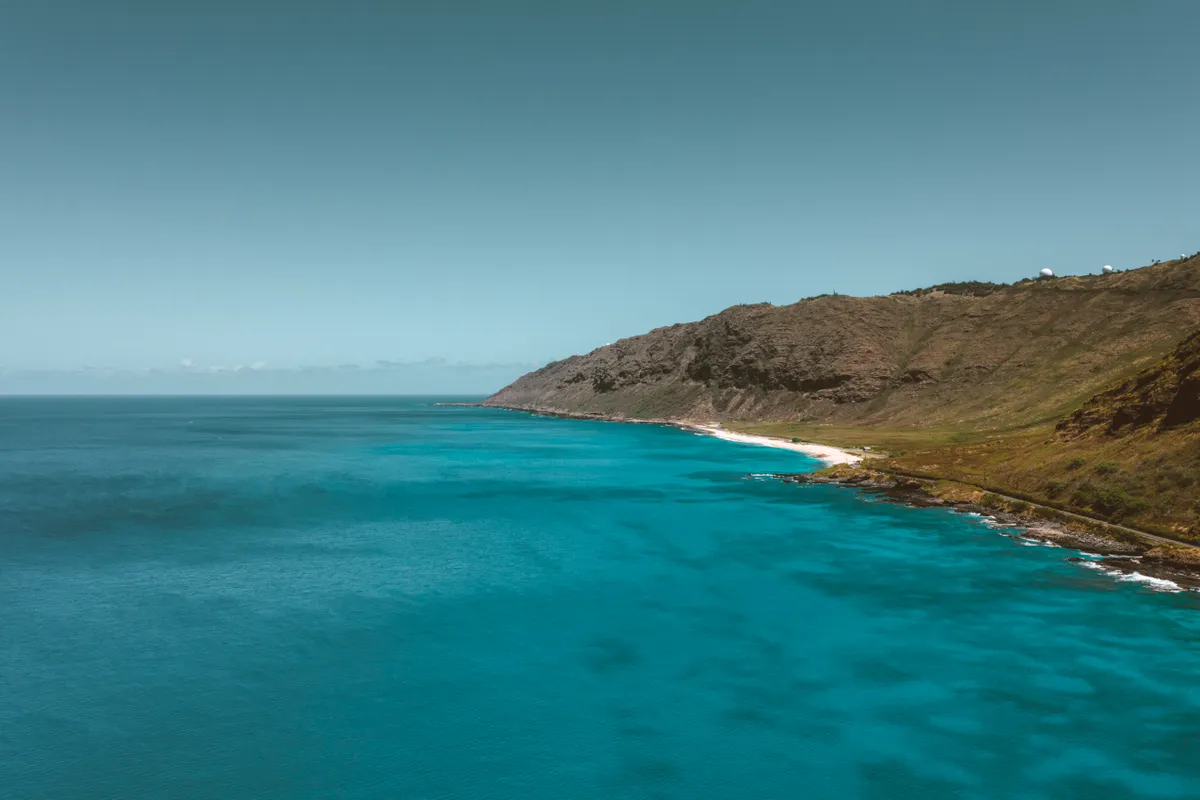 Rugged Oahu coastline with cliffs dropping to the blue Pacific
